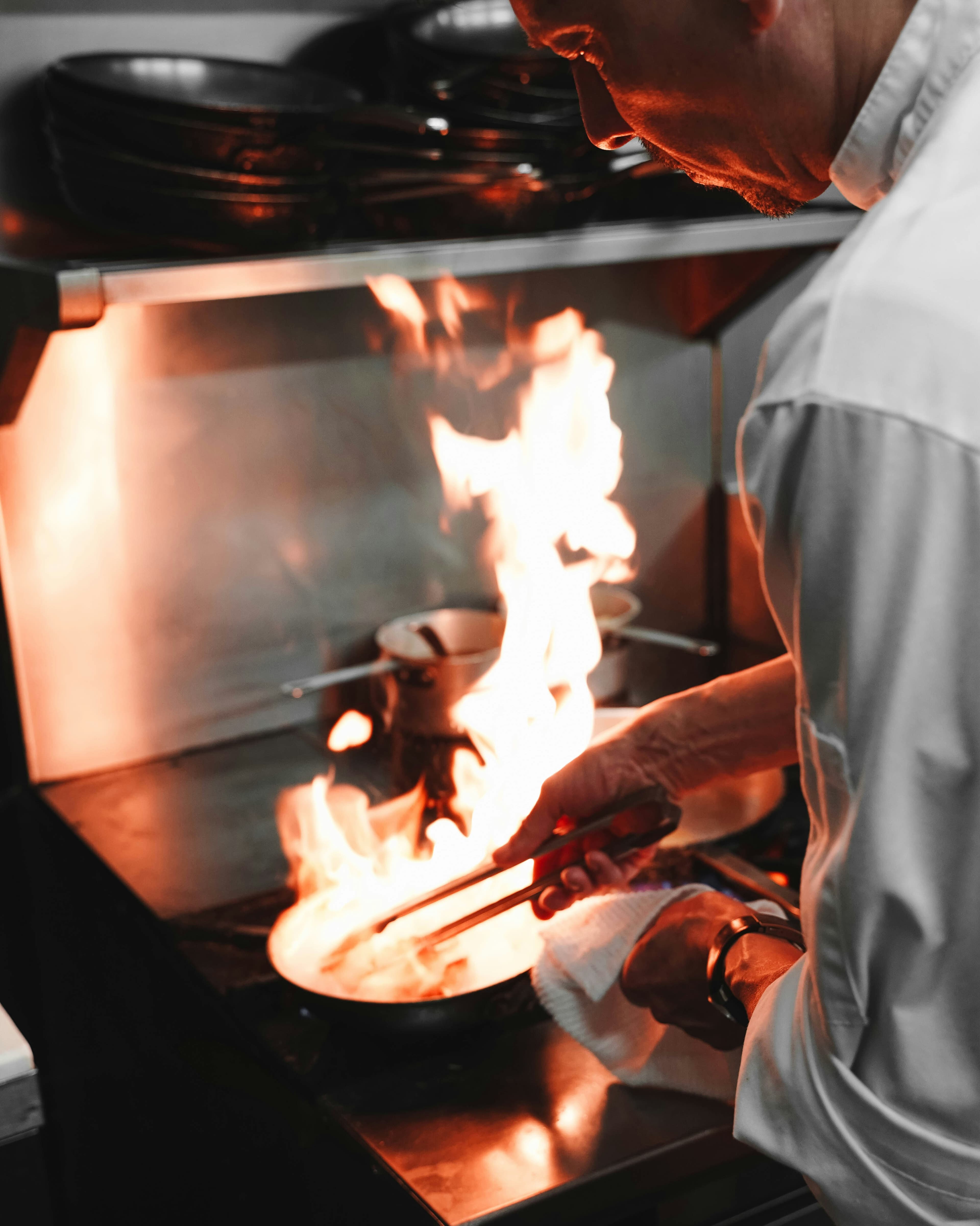 Chef flambéing a pan in the kitchen